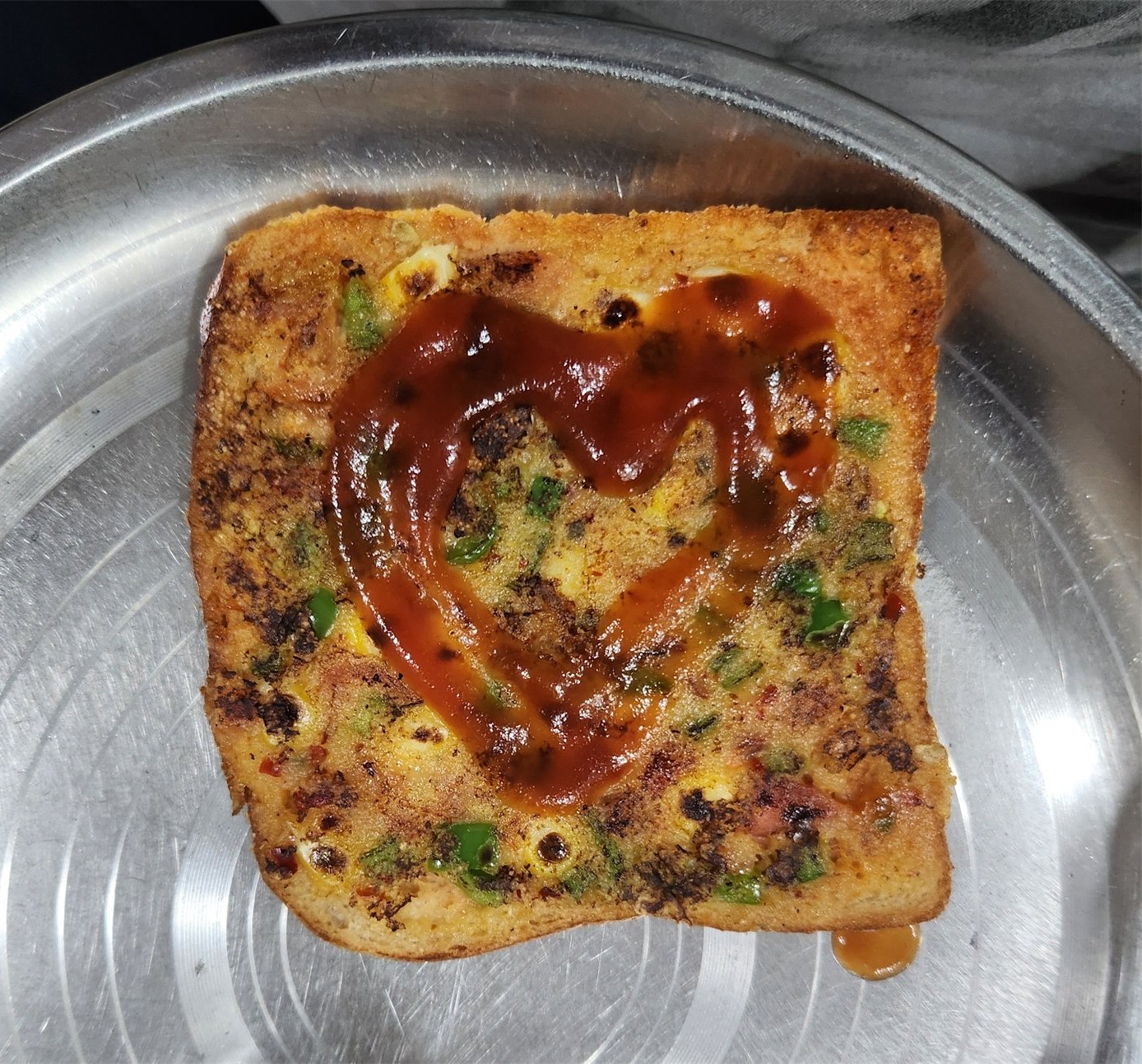 A homemade savory toast decorated with ketchup