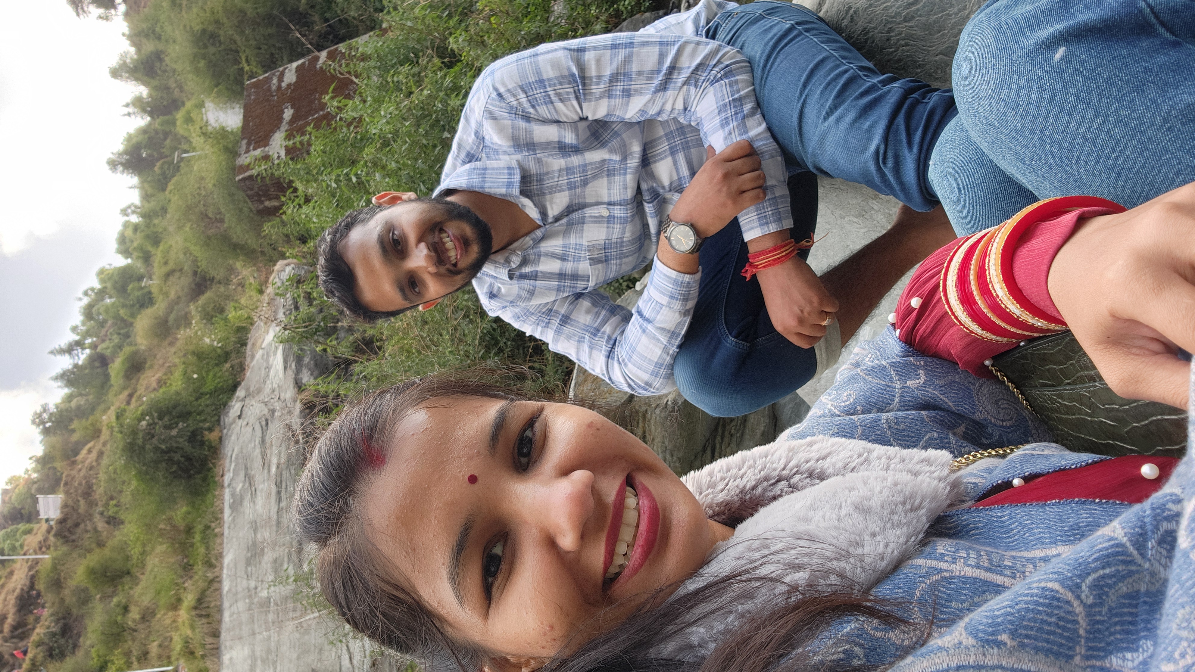 Couple taking a selfie together at a scenic hillside
