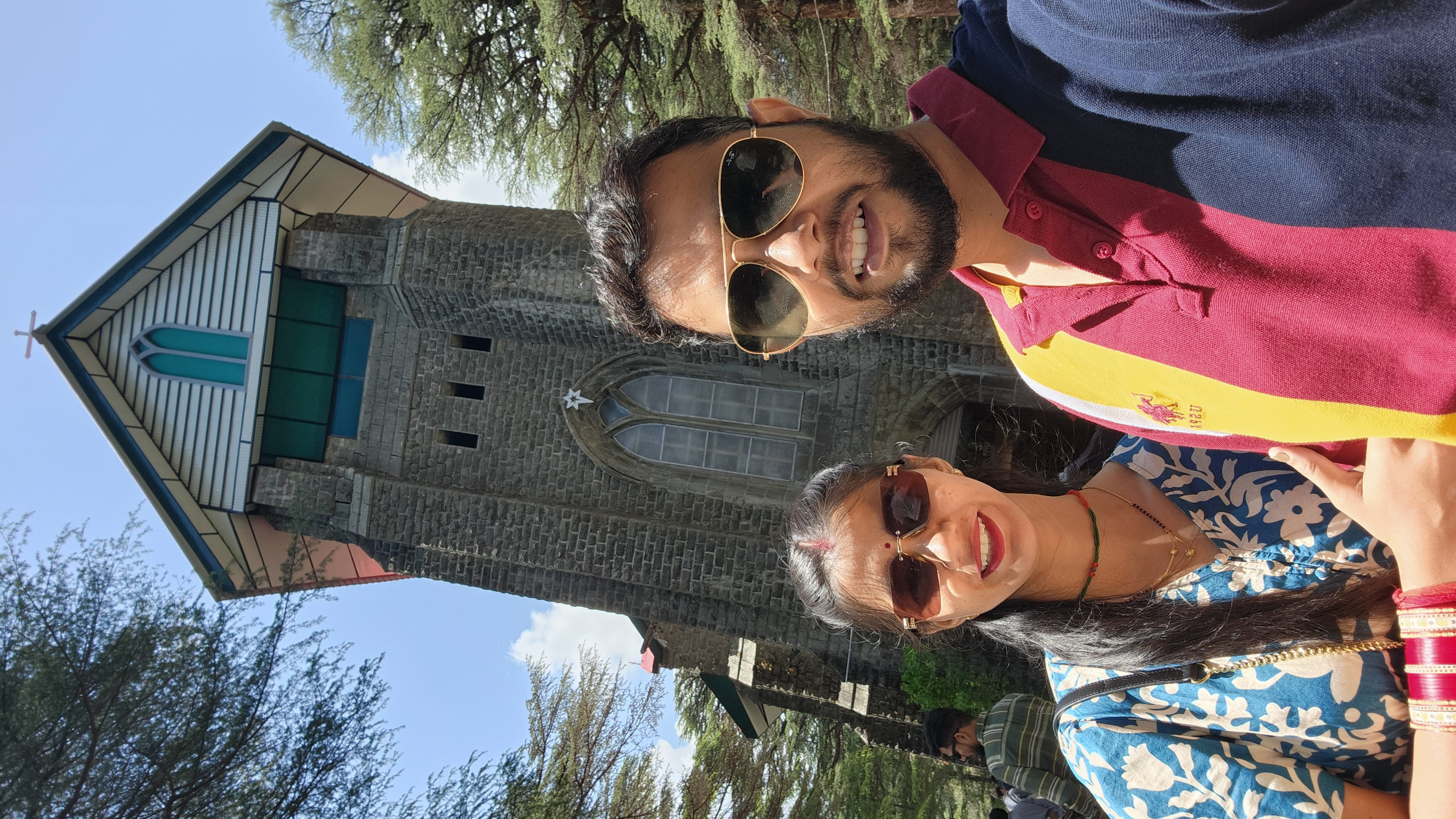 Couple wearing sunglasses outside a historic stone building