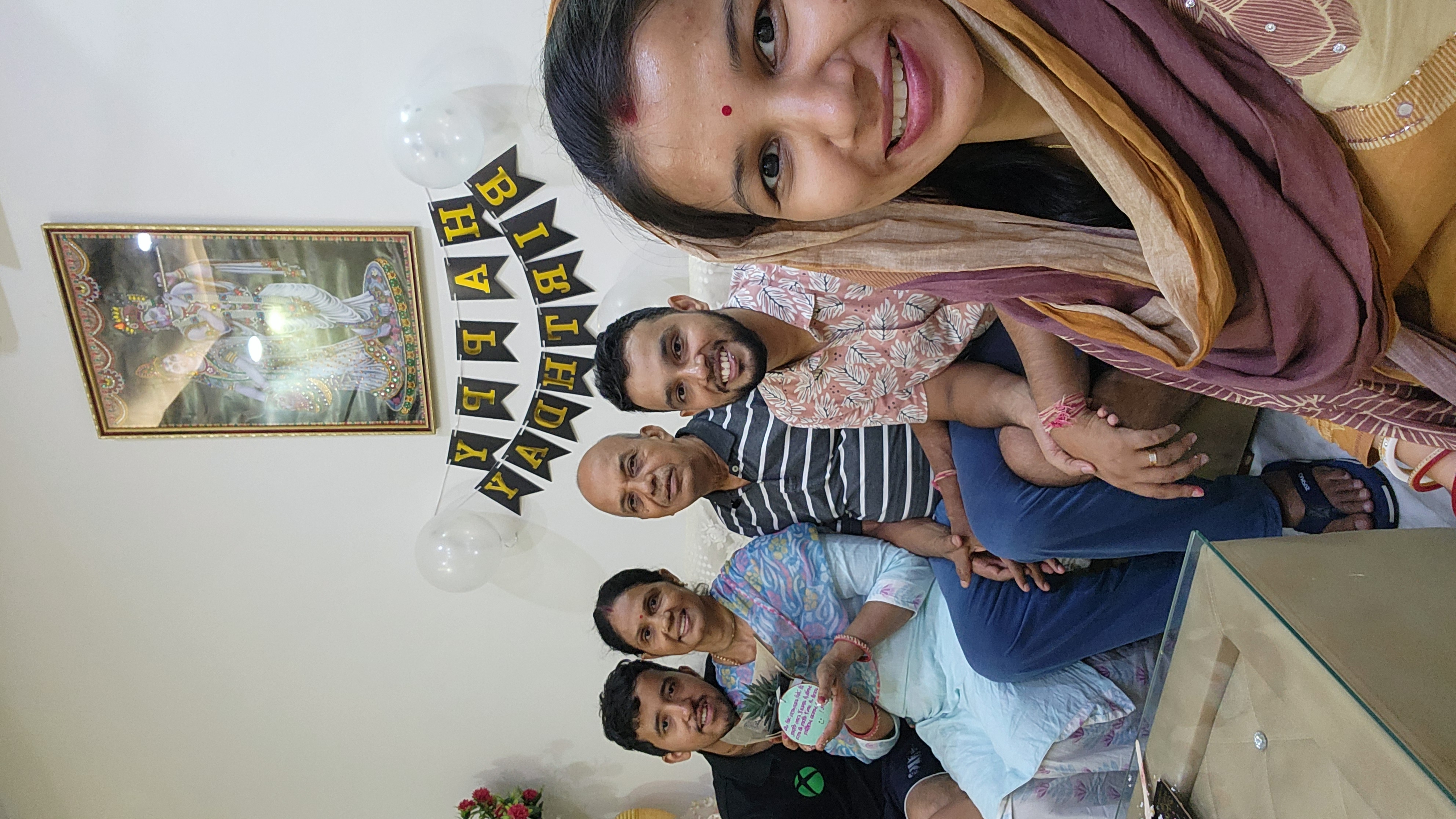 Family smiling together beneath birthday decorations