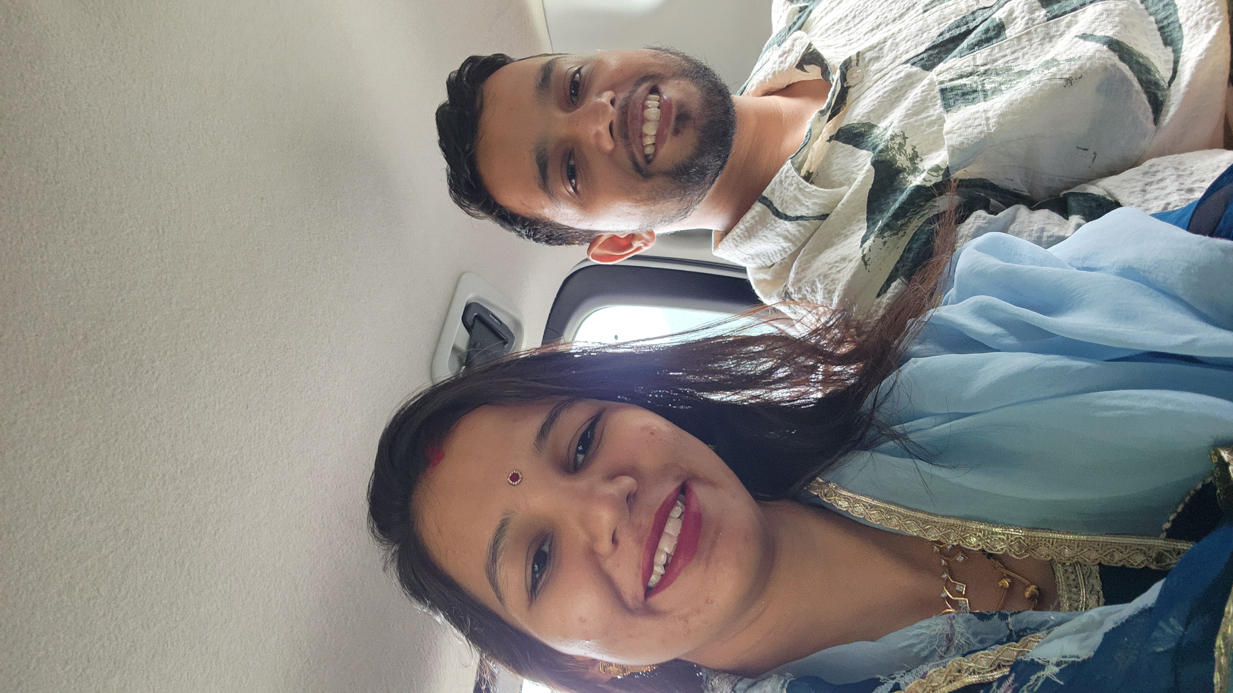 Couple smiling together from the back seat of a car