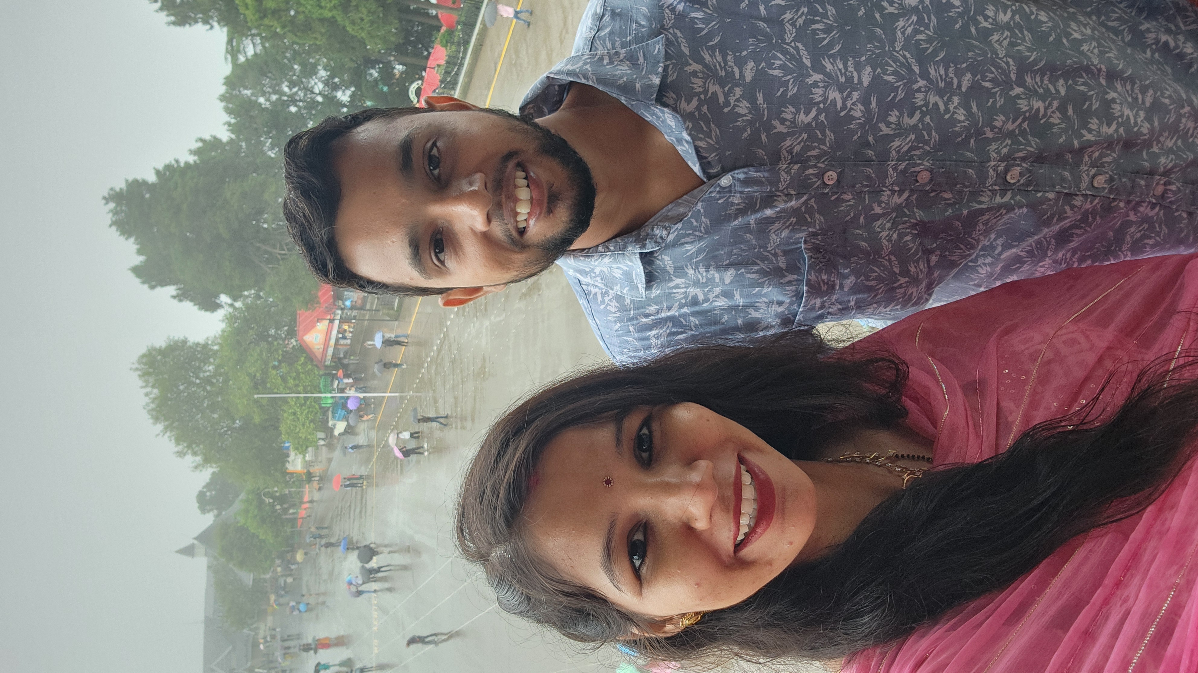 Couple taking a selfie outdoors beneath a cloudy sky