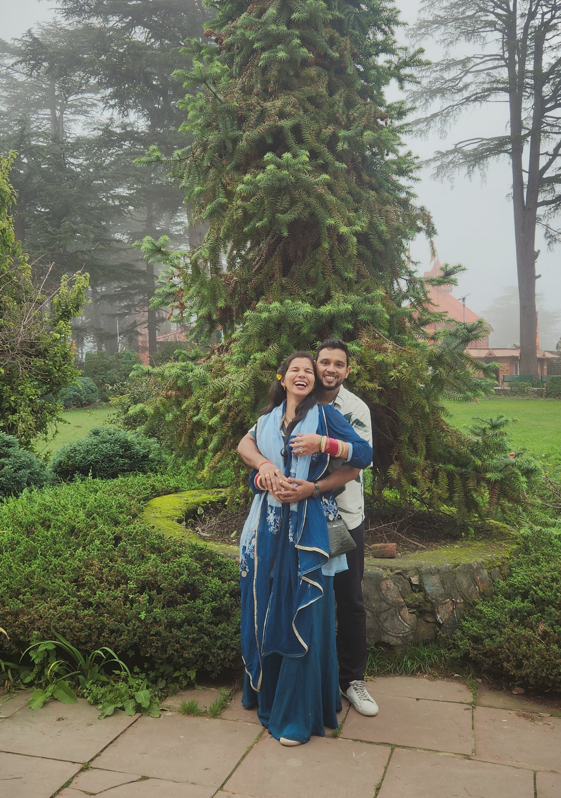 The two of us standing together beneath a tall tree in the mist